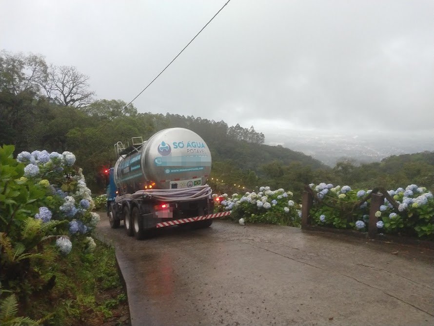 Caminhão-pipa da Só Água Potável em estrada entre hortênsias nos canyons de Praia Grande