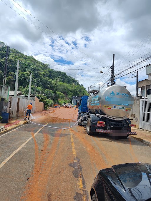 Caminhão-pipa da Só Água Potável lavando rua de Camboriú coberta de lama após as enchentes