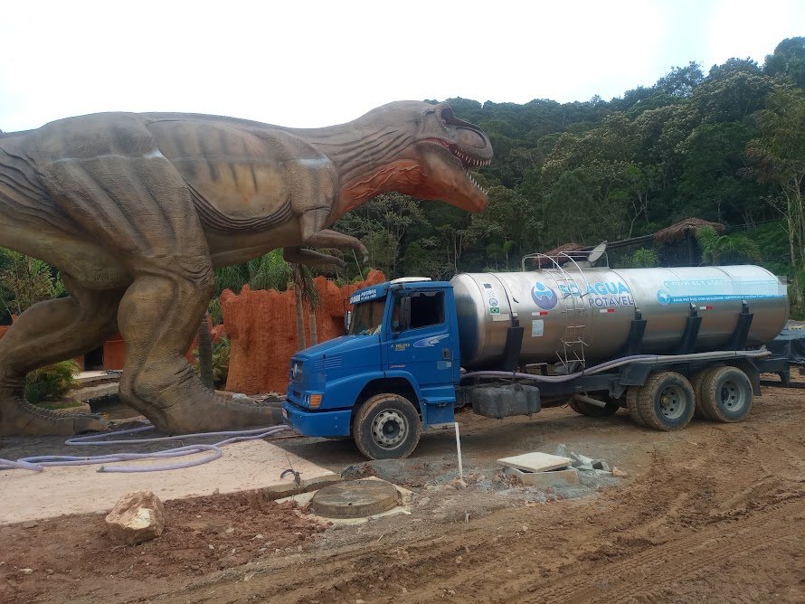 Caminhão-pipa da Só Água Potável ao lado de dinossauro em parque temático de Balneário Camboriú